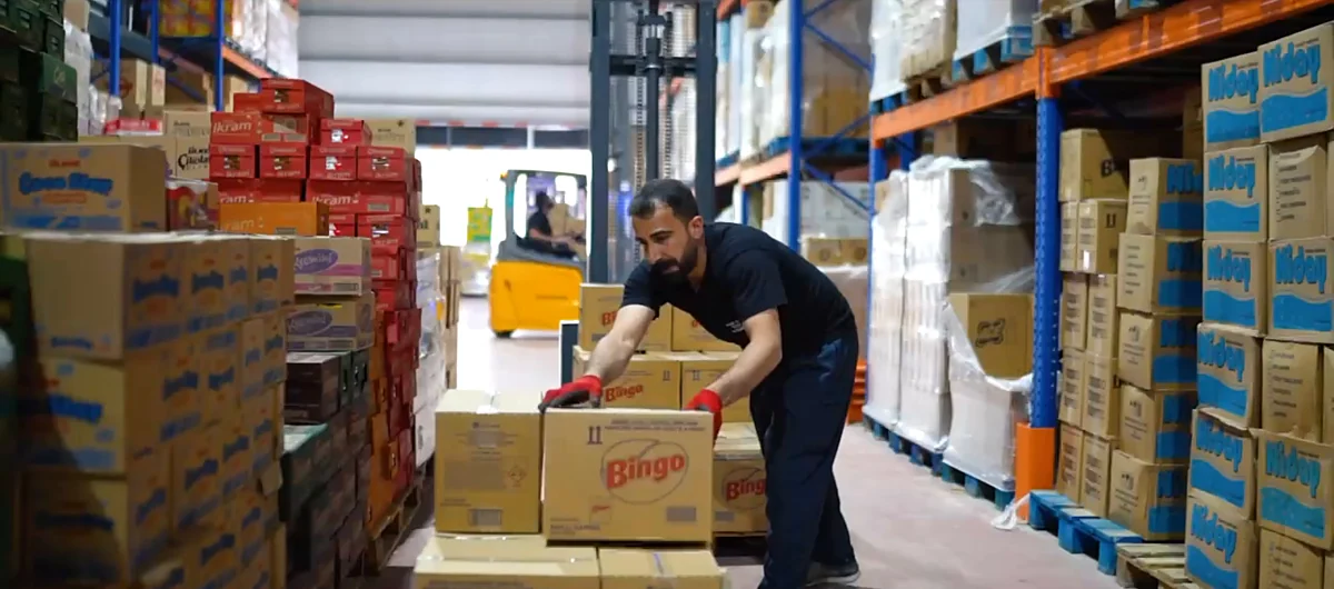 Depo personeli ürün kolilerini taşıyor