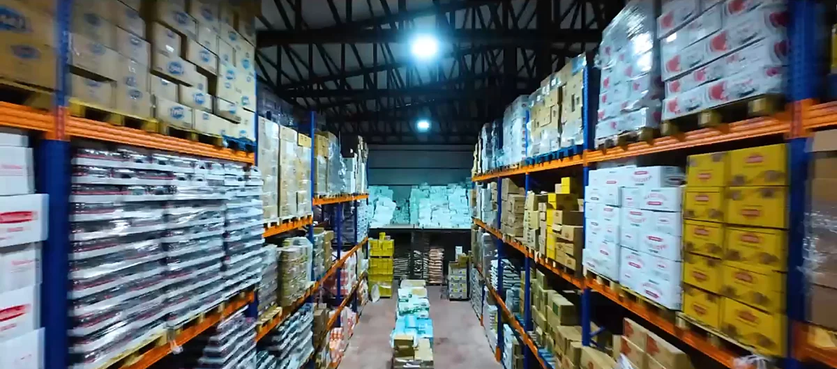 Depo aydınlatması altında raf sıraları